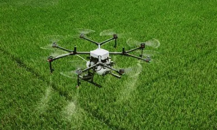 Drone menyemprotkan pupuk di sawah