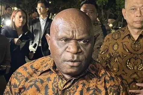 Natalius Pigai di Istana Negara Natalius Pigai mengenakan jas resmi pelantikan kabinet